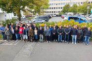 Personengruppe vor einem Parkplatz