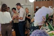 Rosa blühende Pfingstrose, dahinter stehende Personen