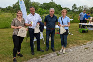 4 Personen stehen im Freien nebeneinander