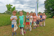 Kinder stehen mit Leinentasche auf Wiese